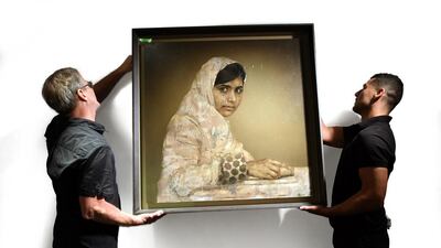 Workers hang a painting by Jonathan Yeo titled Girl Reading (Malala Yousafzai). Yousafzai is the Pakistani schoolgirl shot by the Taliban for campaigning for girls' education. Timothy A Clary / AFP