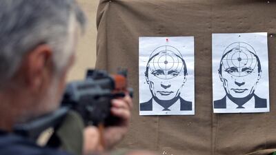 A man shoots at targets depicting a portrait of Russian President Vladimir Putin, in a shooting range in the centre of the western Ukrainian city of Lviv. Yurko Dyachyshyn / AFP