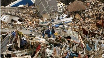 Villagers walk across a sea of debris yestedrday after they visited their home destroyed by a tsunami in Minamisanriku.