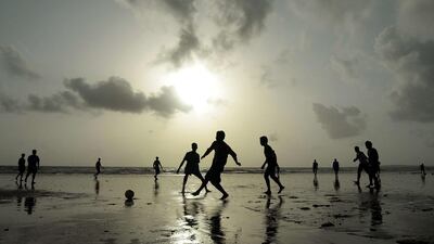 Indian youths play football at Juhu beach in Mumbai, India. Punit Paranipe / AFP