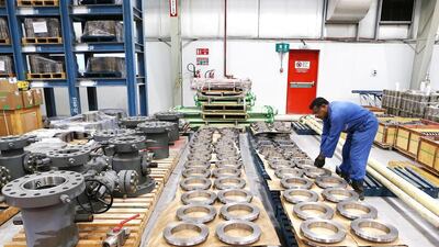 A worker checks valves and manifolds being manufactured at Weir Group's plant at Jebel Ali. Pawan Singh / The National