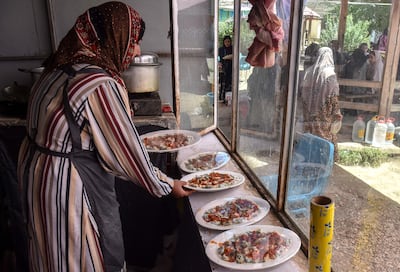 An Afghan woman prepares plates of ashak, a traditional dish. Prices have risen in Afghanistan and around the world. AFP