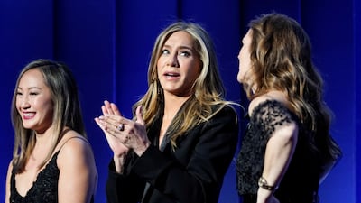 Actresses Jennifer Aniston, centre, and Drew Barrymore, right, react. Reuters