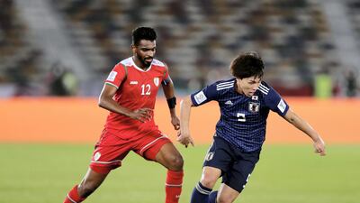 Minamino Takumi of Japan and Ahmed Al Mahaijri of Oman battle during the game. Chris Whiteoak / The National