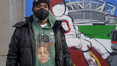Demont Pinder poses next to a mural he painted showing the team's new name. Willy Lowry / The National.