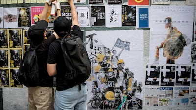 Pro-democracy protesters glue up posters and sticky notes to make a "Lennon Wall" before a rally to mark the fifth anniversary of the 2014 Umbrella Movement. Getty Images