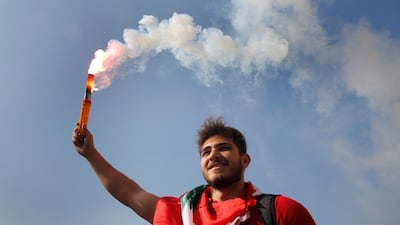 A student protester holds a smoke flare during a protest against the government in front of the education ministry in Beirut. AP Photo