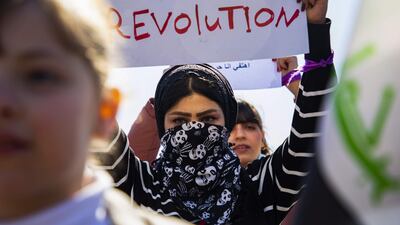 An Iraqi woman raises a placard as she takes part in an anti-government demonstration in the southern city of Basra on February 13, 2020. AFP