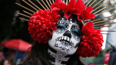 A woman dressed as Catrinas poses for a photo as she joins a parade on Mexico City's iconic Reforma avenue during celebrations for the Day of the Dead in Mexico. AP
