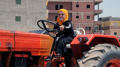The female mechanic gets behind the wheel of a tractor. Reuters