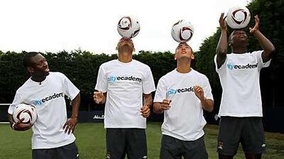 Manchester City's Shaun Wright Phillips, left, poses with academy players Reece Wabara, second left, Ahmad Benali, second right, and Jeremy Helan, right, at the launch of Manchester City's ecademy yesterday.