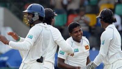 Sri Lanka's Rangana Herath, second right, celebrates with teammates after the dismissal of unseen New Zealand cricketer Jesse Ryder