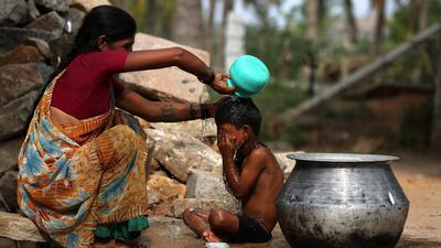 A woman bathes her child to beat the heat in gauribidanur village around 85km from Bangalore. Jagadeesh NV / EPA