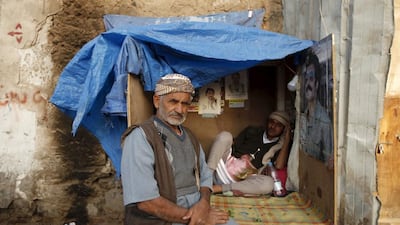 A man sits next to a street guard in his kiosk at the old quarter of Yemen's capital Sanaa (REUTERS/Khaled Abdullah)
