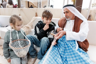 An Emirati artisan demonstrates maritime craft techniques to young visitors at Discover Abu Dhabi. Photo: National Media Authority