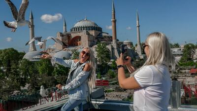 Ukrainian tourists pose for a picture near the Hagia Sophia Mosque at Sultanahmet in Istanbul. AFP