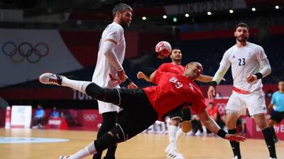 Egypt's pivot Mohamed Mamdouh Shebib shoots past France's pivot Luka Karabatic and Ludovic Fabregas.