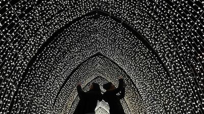 Visitors walk through the 'By Frost' tunnel of lights during a photocall at Kew Gardens in south west London, during an event to promote the launch of the "Christmas at Kew" event. AFP