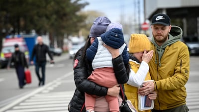 A Ukrainian refugee holding her child arrives at the Siret border crossing between Romania and Ukraine. AFP