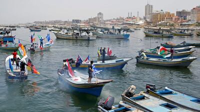 Palestinians ride boats with flags during an event to show solidarity with countries affected by the coronavirus disease . Reuters