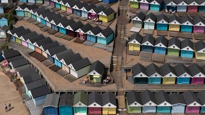 Sunbathers among rows of beach huts in Walton-on-the-Naze, Essex, as temperatures pass 30°C in parts of the UK. Getty Images