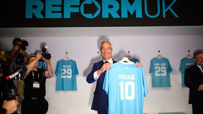 Mr Farage poses with a named shirt on day one of the Reform UK conference in Birmingham in November 2025