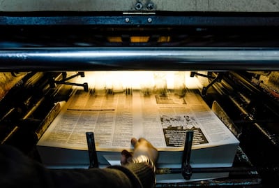 A technician retrieves a freshly-printed page of the Afrika Gazetesi newspaper's forthcoming edition from the printing press. AFP