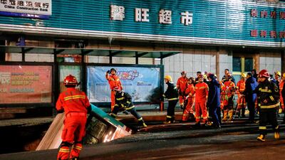 Chinese rescuers prepare to lift a bus out of the sinkhole. AFP