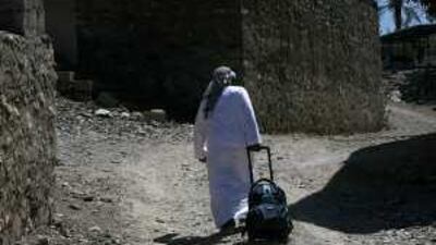 Mohammed Abdullah Mohammed, 10, drags his school bag up a dirt road on his way in Tayyibah.