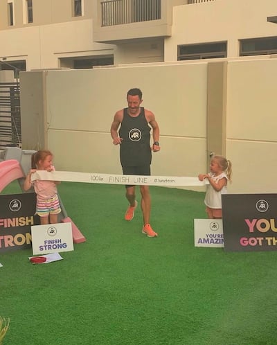 Lee Ryan crosses a homemade finish line, with the support of his daughters, Lily and Sophia. Courtesy Lee Ryan