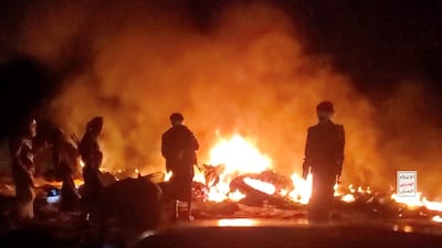 Yemenis stand near what Houthi military media said was an American MQ9 Reaper drone shot down by the Iran-backed group in Al Jawf governorate on Saturday. Photo: Houthi military media / Reuters