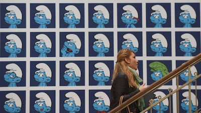 A visitor walks past a panel exhibiting characters from the Belgian comic series The Smurfs created by Belgian cartoonist Peyo (pen name of Pierre Culliford), in the Centre Belge de la Bande Dessinee (Belgian Comic Strip Center) on October 3, 2014 in Brussels.