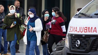 People wear face masks as they walk outside of the Rafic Hariri University Hospital. EPA