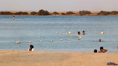 People swim at Pure Beach in King Abdullah Economic City.