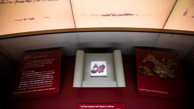 A tiny fragment of what the Museum of the Bible thought was part of the Dead Sea Scrolls (bottom) turned out to be fake at the Museum of the Bible in Washington DC. EPA