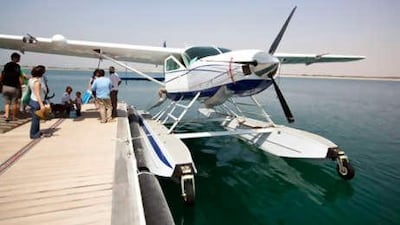 The seaplane's arrival at Sir Bani Yas Island. Below, Rick Reinke, the pilot, oversees the unloading of luggage.