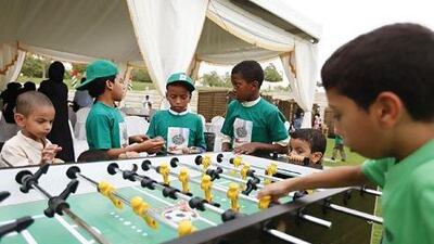 Orphans play foosball at Zabeel Park.