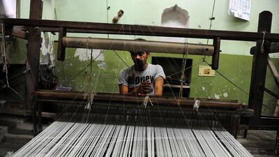 An labourer weaves a sari at a factory in Rajapura Varanasi. (Sanjay Kanojia / AFP Photo / April 22, 2014)