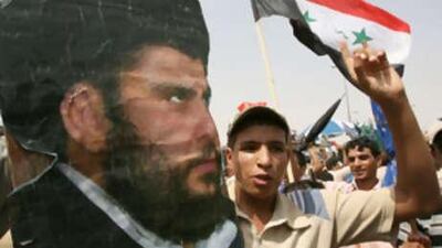 A poster of radical Shiite cleric Muqtada al Sadr is held up during a protest against the negotiated security plans following the weekly Friday prayers in Sadr City.