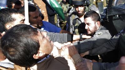 An Israeli border guard grabs Palestinian official Ziad Abu Ein, left, during a demonstration in the village of Turmus Aya near Ramallah, on December 10, 2014. Abbas Momani / AFP Photo