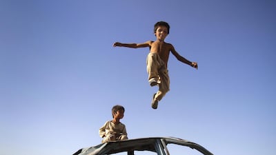 An Afghan boy jumps down from a vehicle in Kabul, Afghanistan, Thursday, July, 5, 2012. (AP Photo/Ahmad Jamshid)