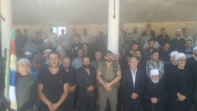Mourners stand at the funeral prayers for Mr Al Jaramani