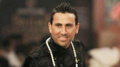 The Pakistani test cricketer Younis Khan presents a creation during Bridal Couture Week in Karachi.