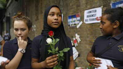 School children arrive to lay flowers in tribute to the victims of a van attack in the Finsbury Park area of north London. Tolga Akmen / AFP