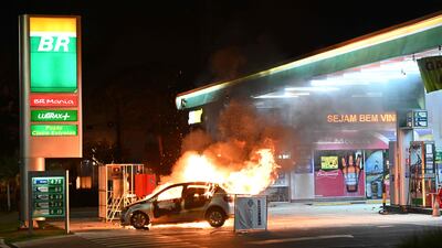 A car burns at a petrol station after clashes between riot police and supporters of Jair Bolsonaro in Brasilia. AFP