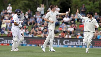 New Zealand's Tim Southee, centre, is congratulated by teammate Tom Blundell after dismissing India's Ajinkya Rahane, left. AP