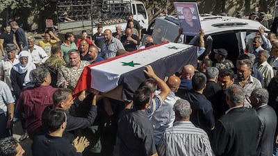 Syrian mourners carry coffins of victims of an ISIS attack on Sweida, 26 July 2018. SANA