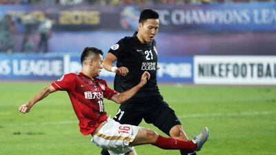 Guangzhou Evergrande’s Huang Bowen, right, is denied possession by Al Ahli’s Walid Abbas during the Asian Champions League final’s second-leg match. AFP