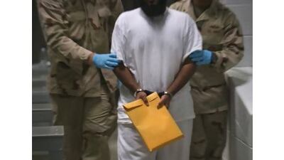 US military guards with a detainee at the US Detention Centre in Guantanamo Bay, Cuba.