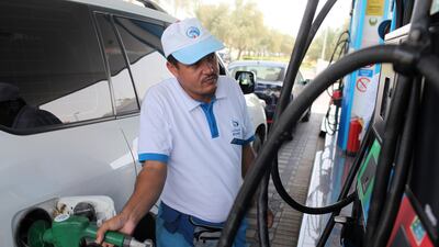 An Adnoc attendant is seen filling a car with petrol in Abu Dhabi. Petrol prices in the UAE have reflected the trend in the global oil market. Sammy Dallal / The National